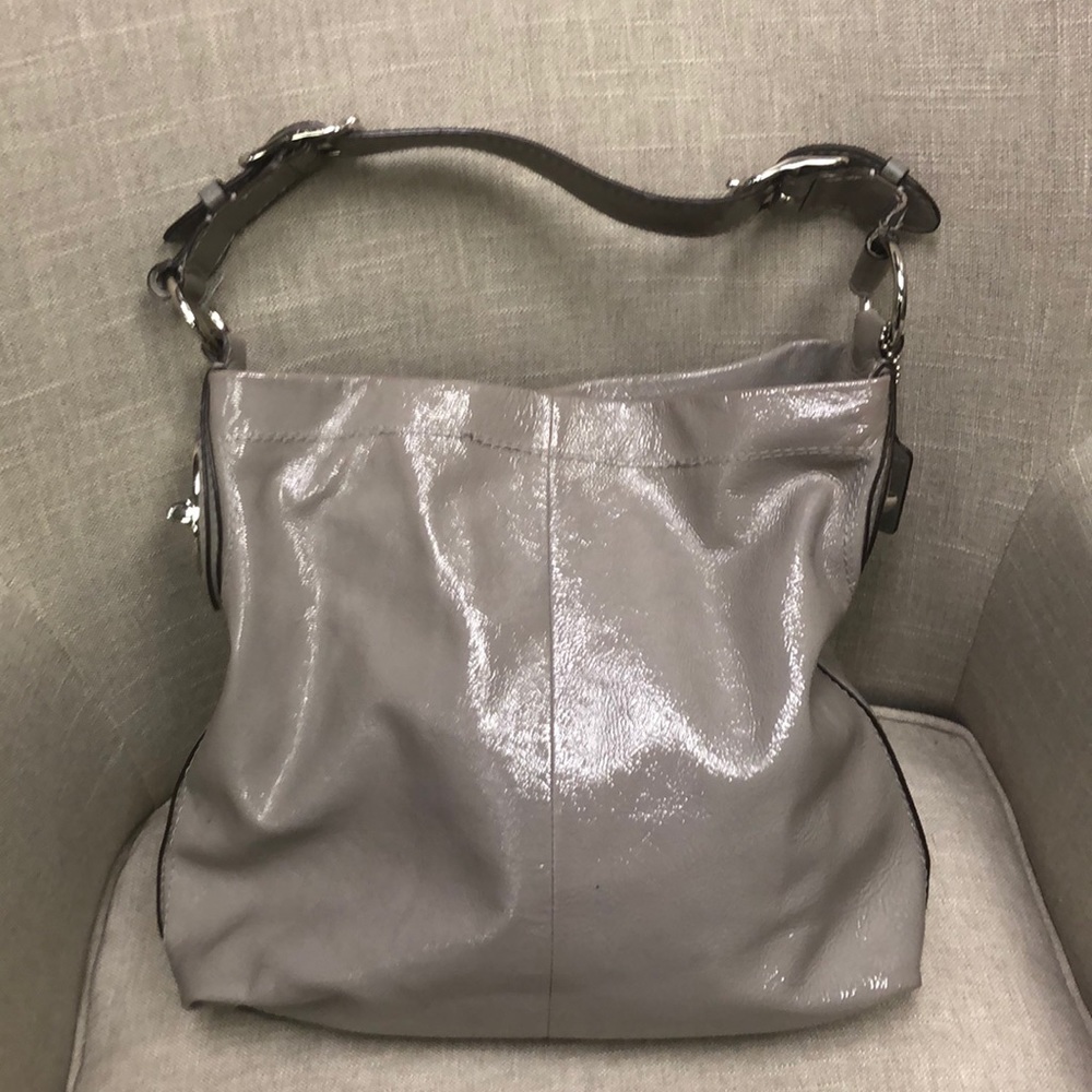 Gray silver patent leather Coach purse.